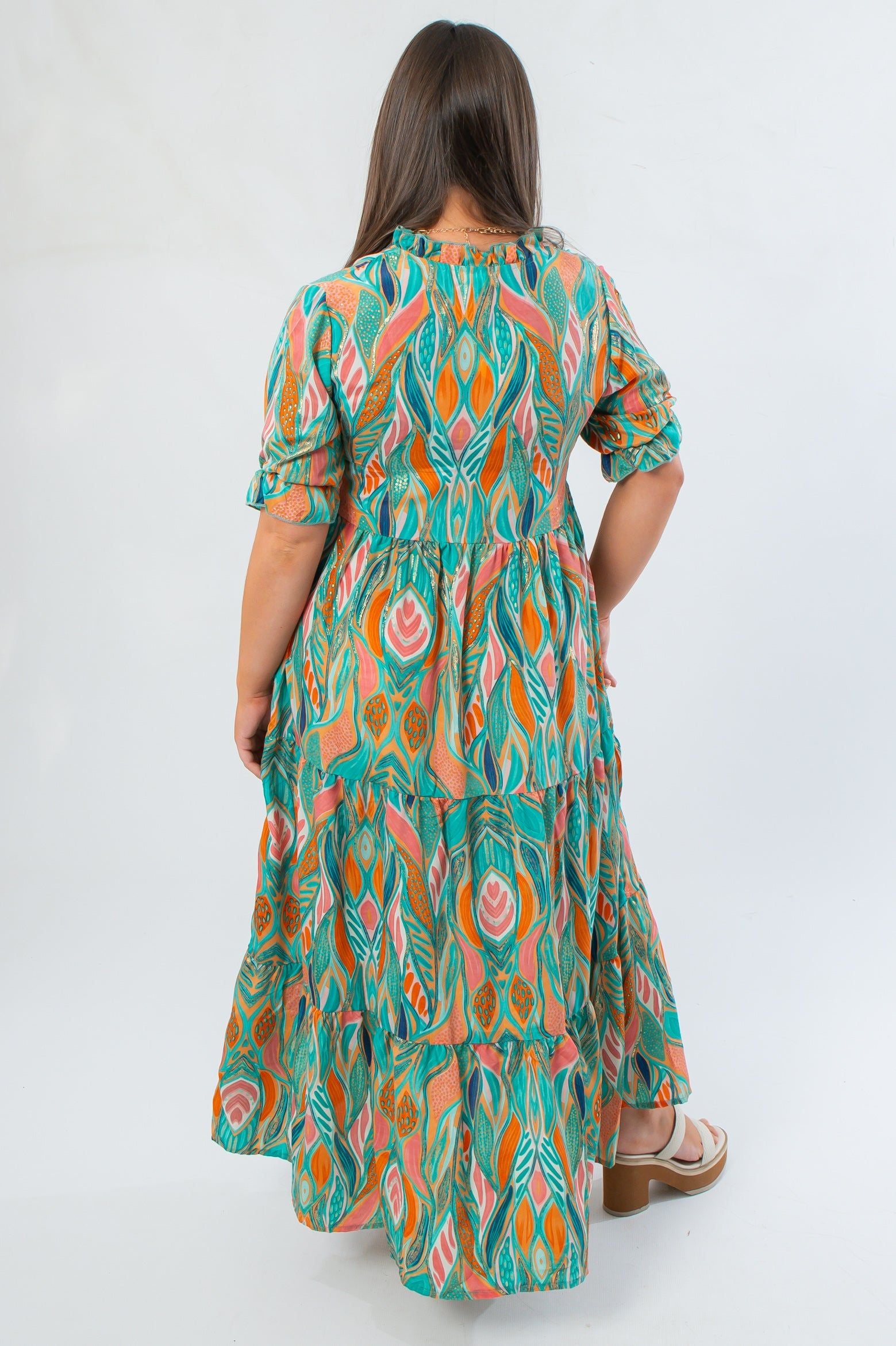 Back view of Mahi Maxi Dress in sea foam green with bold multicolor pattern, elastic waist, and ruffled tiered layers for a flattering fit.