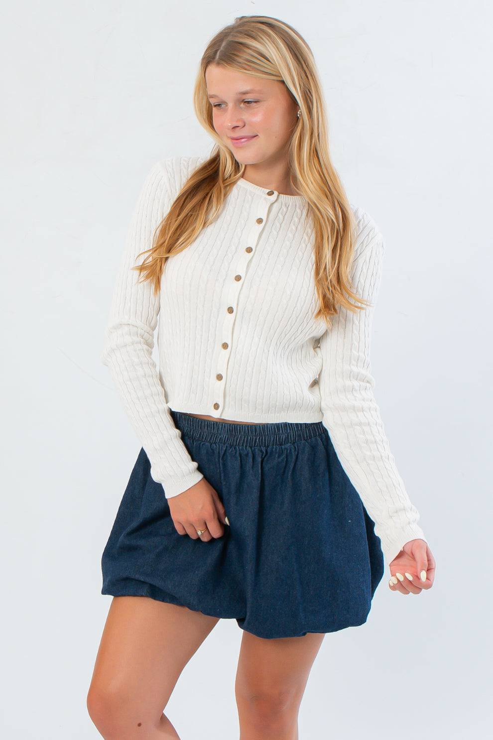 Cream Cable Knit Button Front Cardigan – Cozy Fall Essential featuring a cropped fit and ribbed texture, styled with a navy skirt for fall fashion.