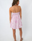 Pink abstract mini dress with strapless style worn by a woman