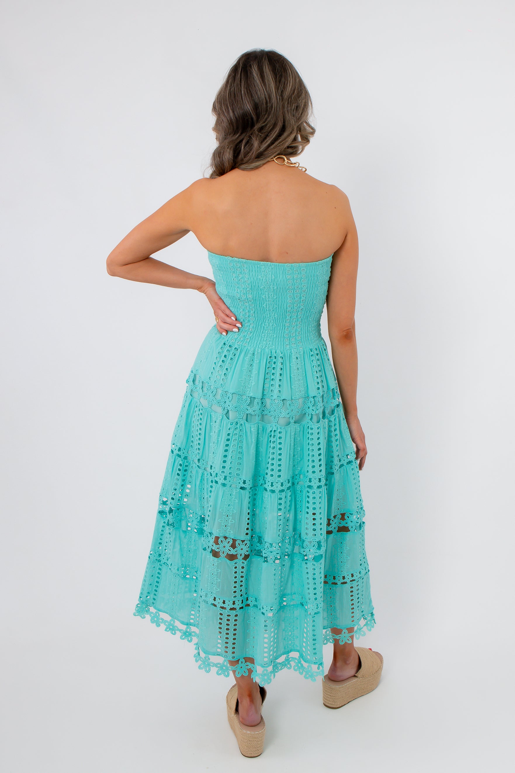 Back view of Aquamarine Moment Eyelet Lace Strapless Dress featuring a smocked bodice and intricate lace tiers in a vibrant Tiffany blue.