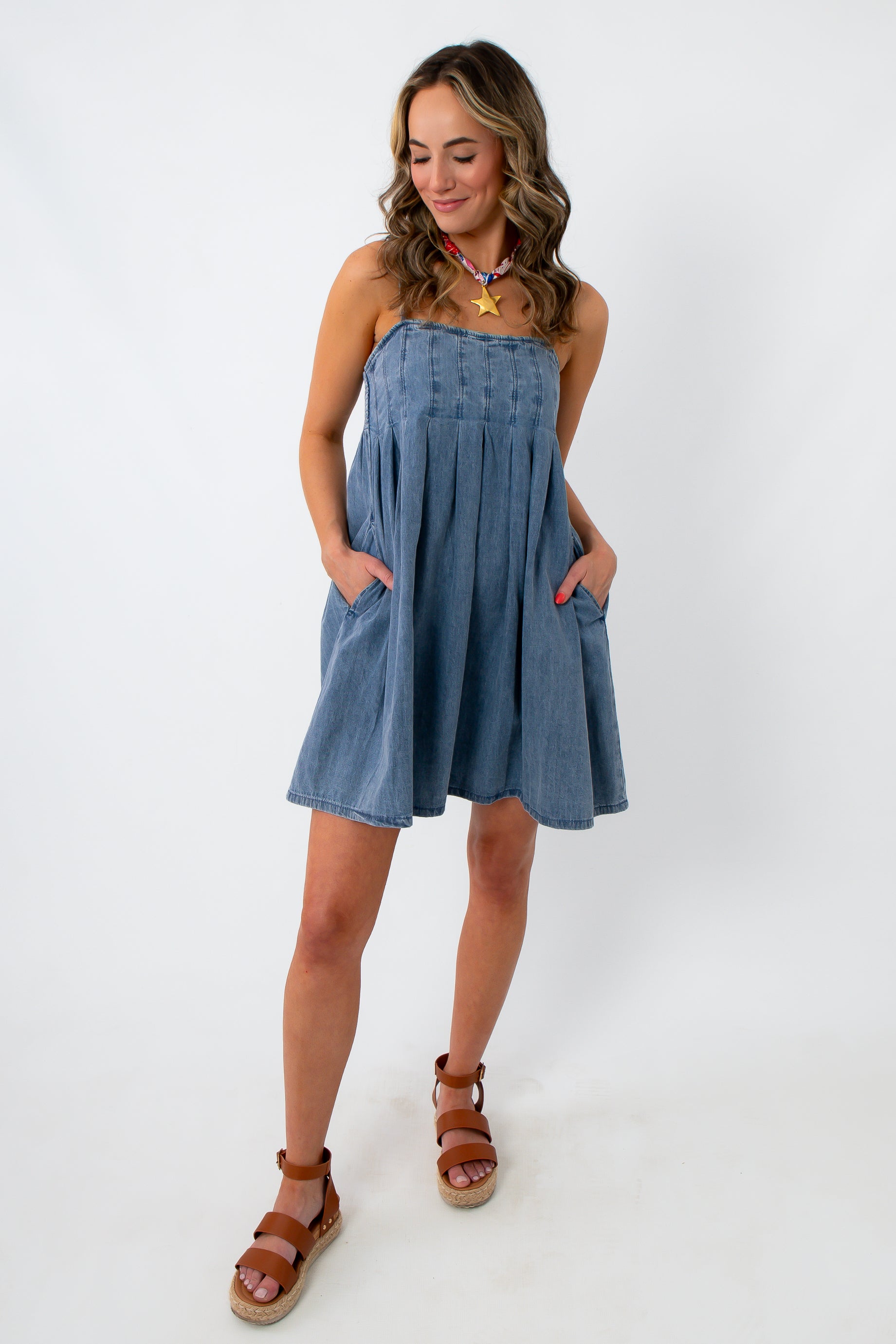 woman in denim mini dress with pockets and adjustable straps