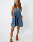 woman in denim mini dress with pockets and adjustable straps