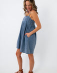 back view of woman in denim dress with elastic waist and pockets