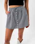 close-up of checkered mini skirt with button details