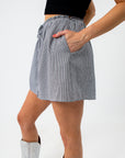 back view of woman in checkered skirt with hand in pocket