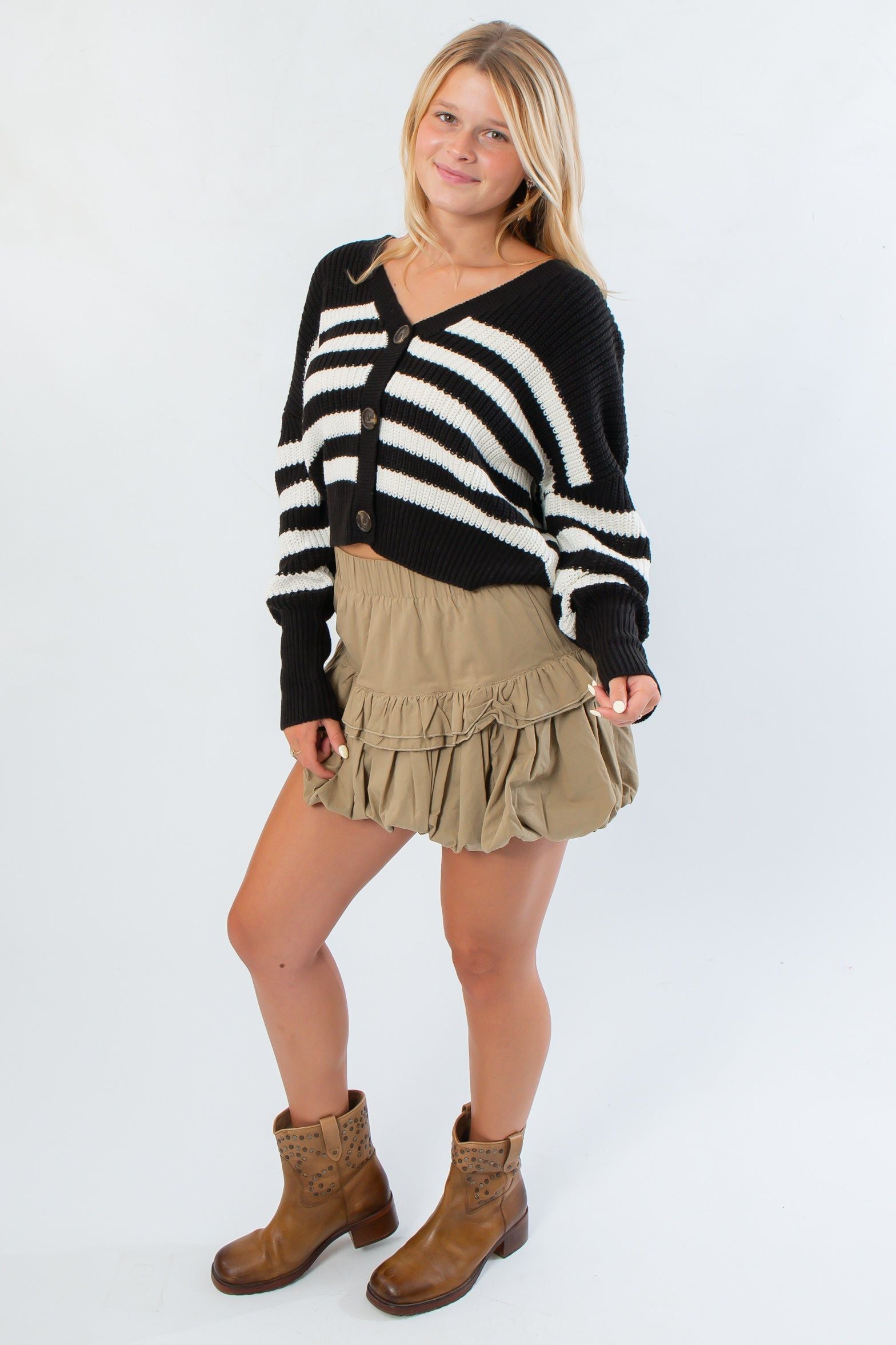 VM Black and White Stripe Cardigan styled for fall with a khaki ruffle skirt and brown boots, ideal for layering in cooler weather.