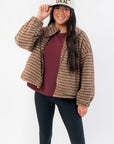 Mocha Stripe Front Zip Jacket in fuzzy brown fabric with front zipper and collar, styled with black leggings and a 'Support Local' cap.