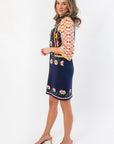 Side view of Penny Lane Navy Jacquard Sweater Dress showcasing its tailored fit and vibrant sleeve pattern, perfect for Thanksgiving outfits.