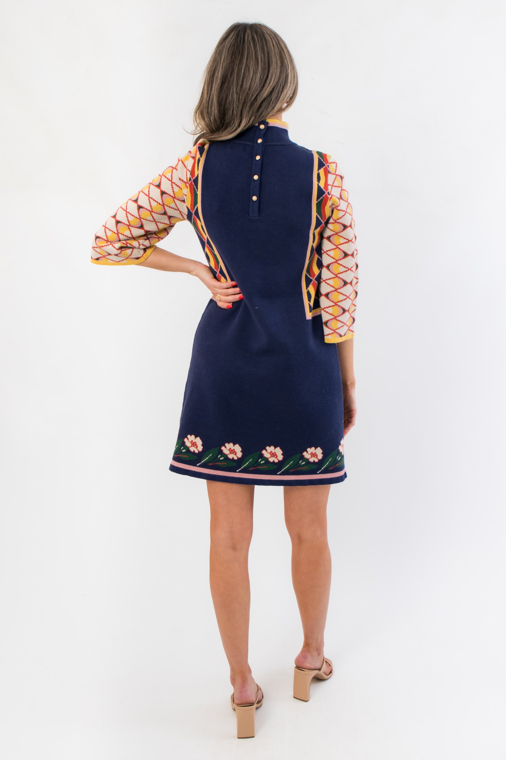 Back view of Penny Lane Navy Jacquard Sweater Dress with button detail and floral hem, combining comfort and style for fall occasions.