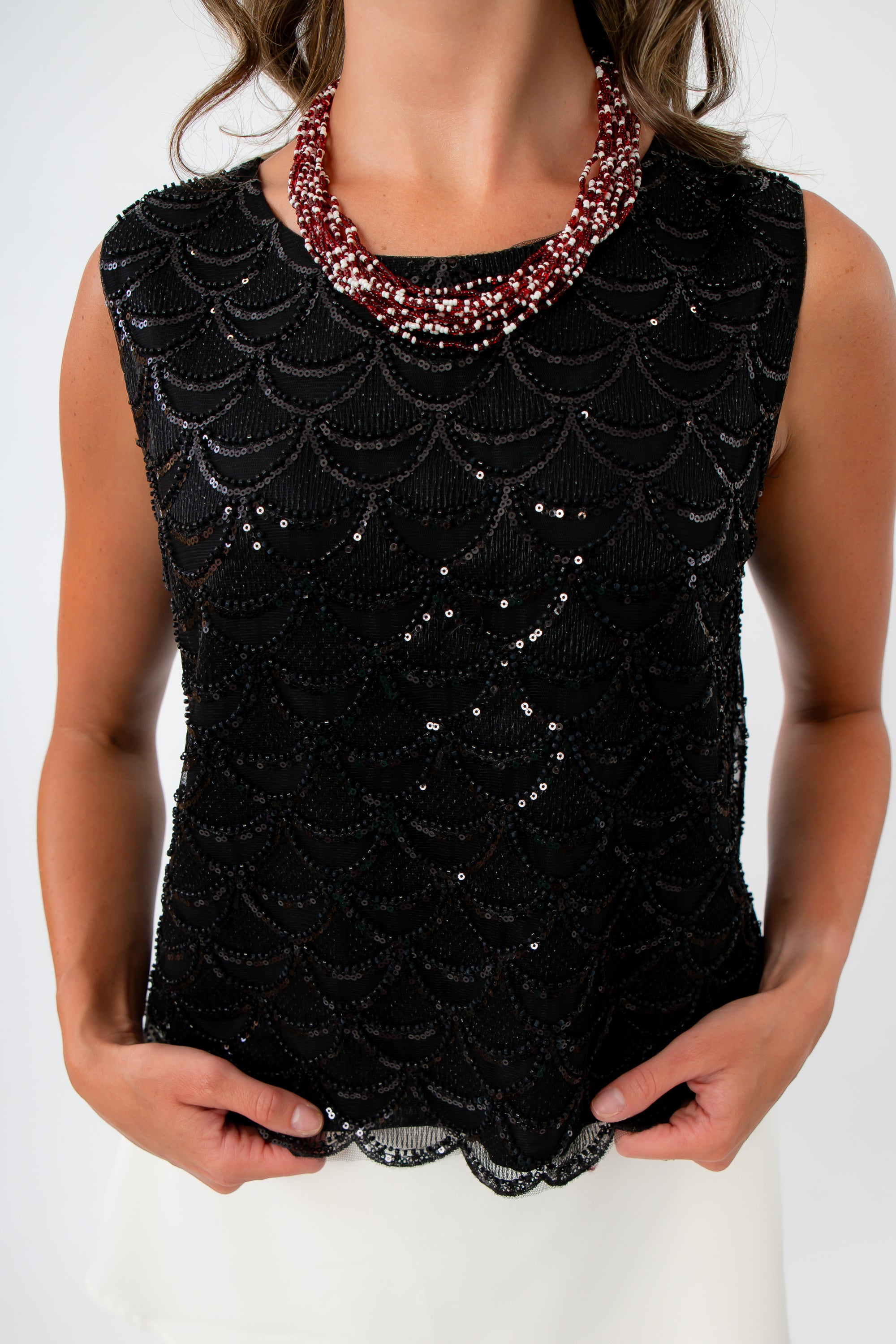 Black sequin top for dinner date with scallop trim and white mini skirt for game day look