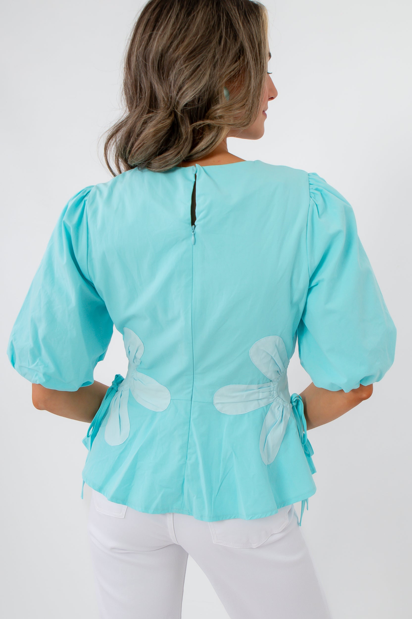 Back view of aqua floral poplin top with puff sleeves