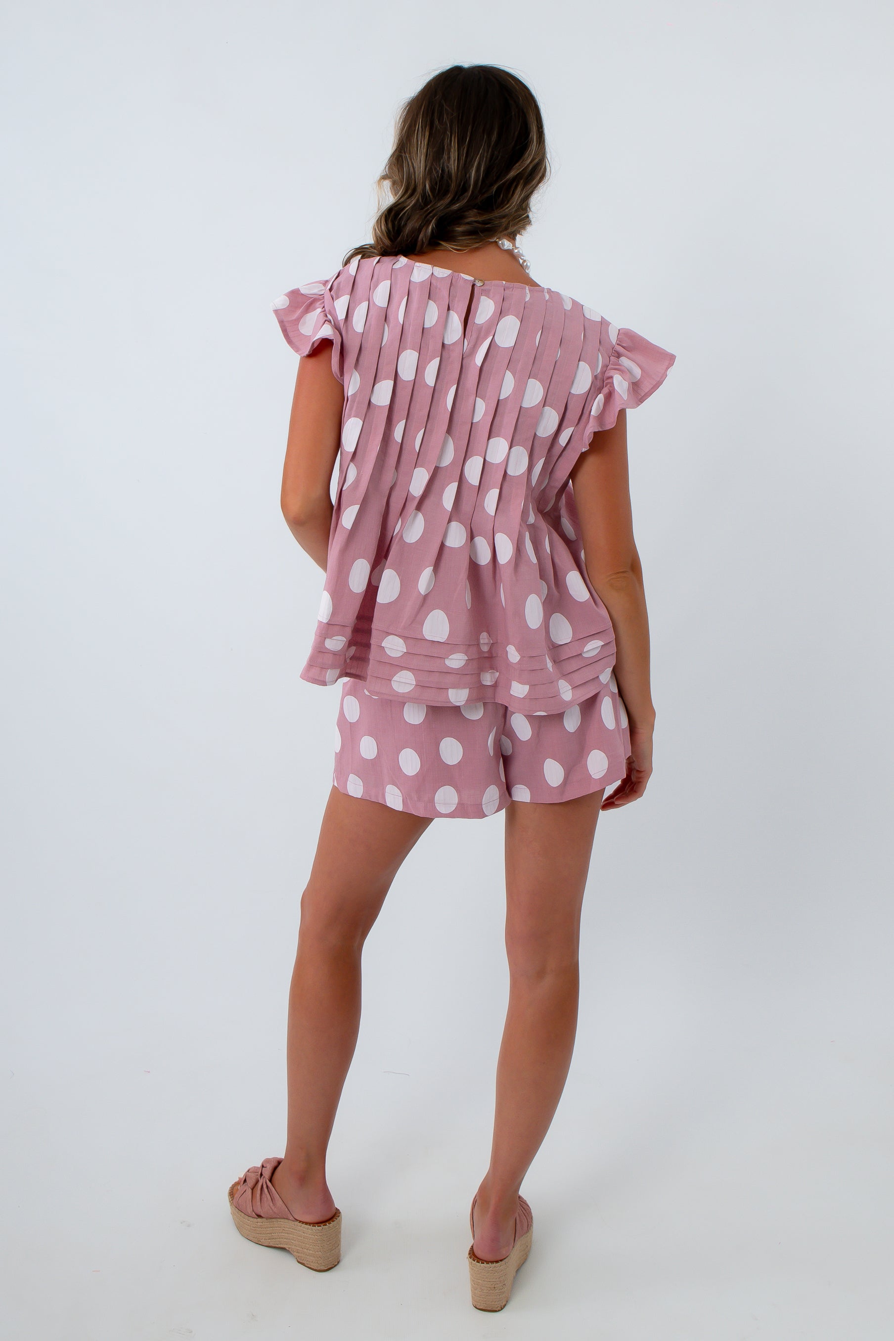 Pink two-piece set with pockets, pink and white polka dot shorts and matching blouse