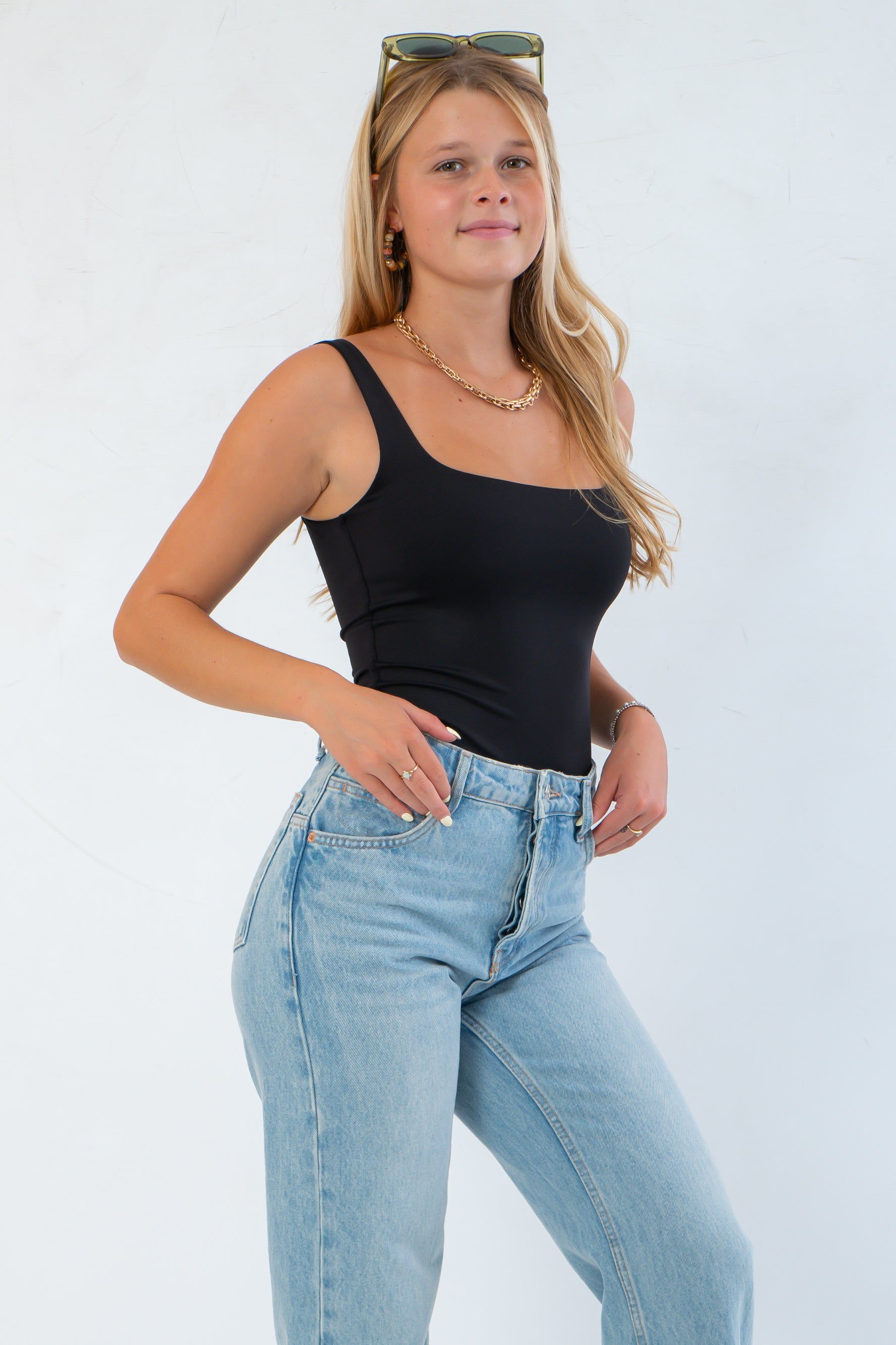 Side view of RD Style Scoop Bodysuit Black, showcasing its form-fitting, moisture-wicking fabric ideal for solo wear or layering in fall outfits.
