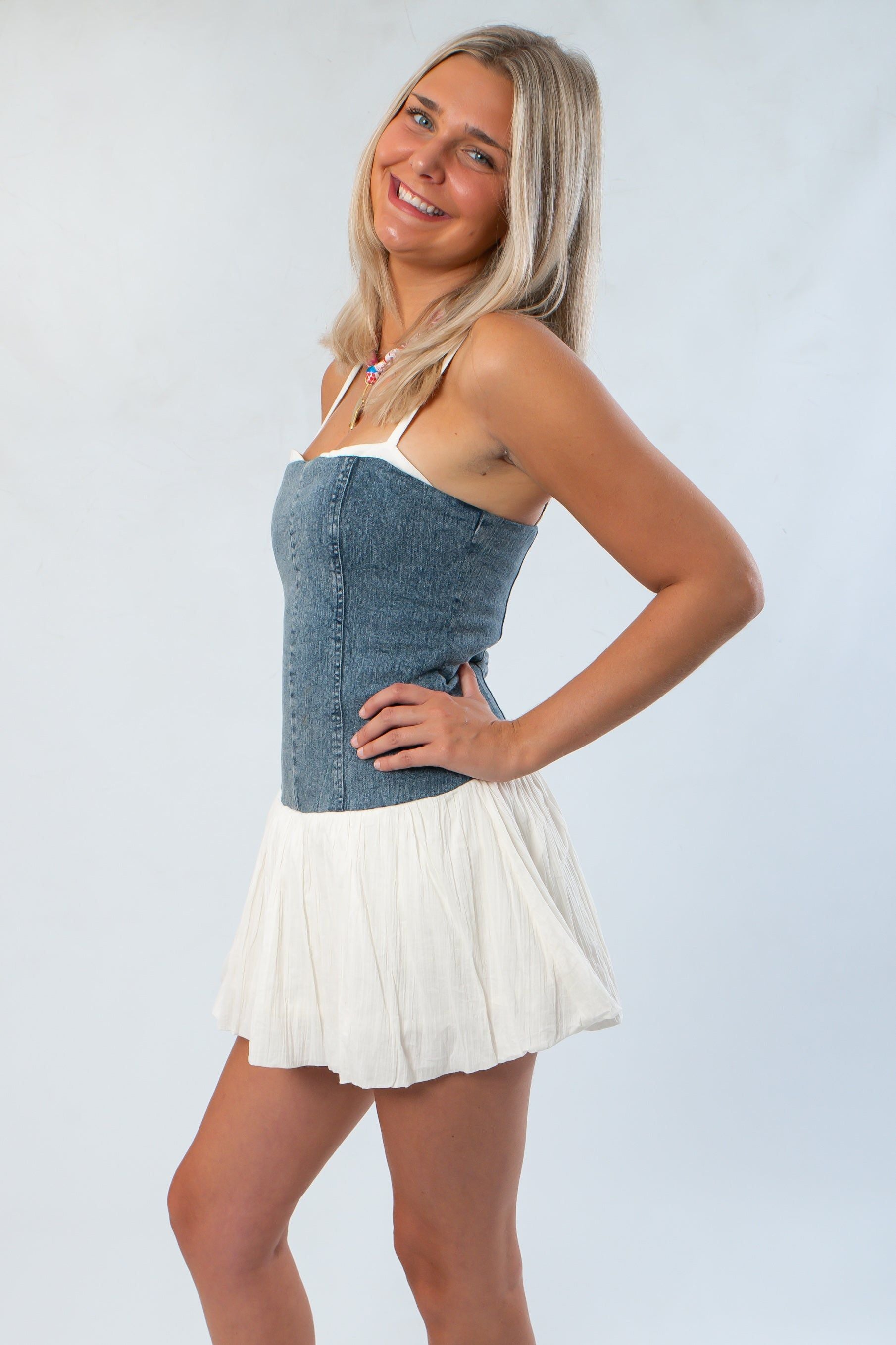 Side view of the Denim Tiffany Skort Dress from Show Me Your Mumu, showcasing its flattering fit and playful skort silhouette for stylish comfort.