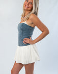 Side view of the Denim Tiffany Skort Dress from Show Me Your Mumu, showcasing its flattering fit and playful skort silhouette for stylish comfort.