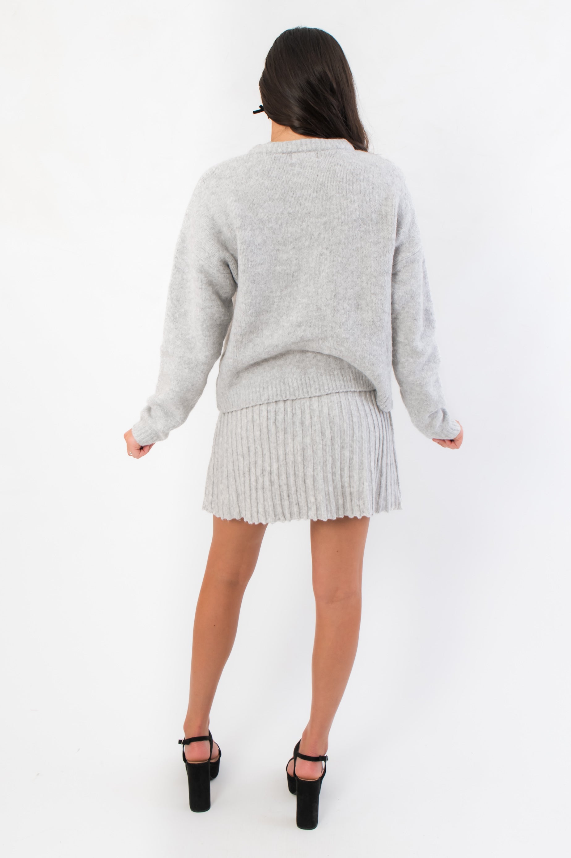 Back view of Livia Grey Button Up Sweater Skirt Set highlighting the soft knit fabric and flattering mini skirt silhouette.