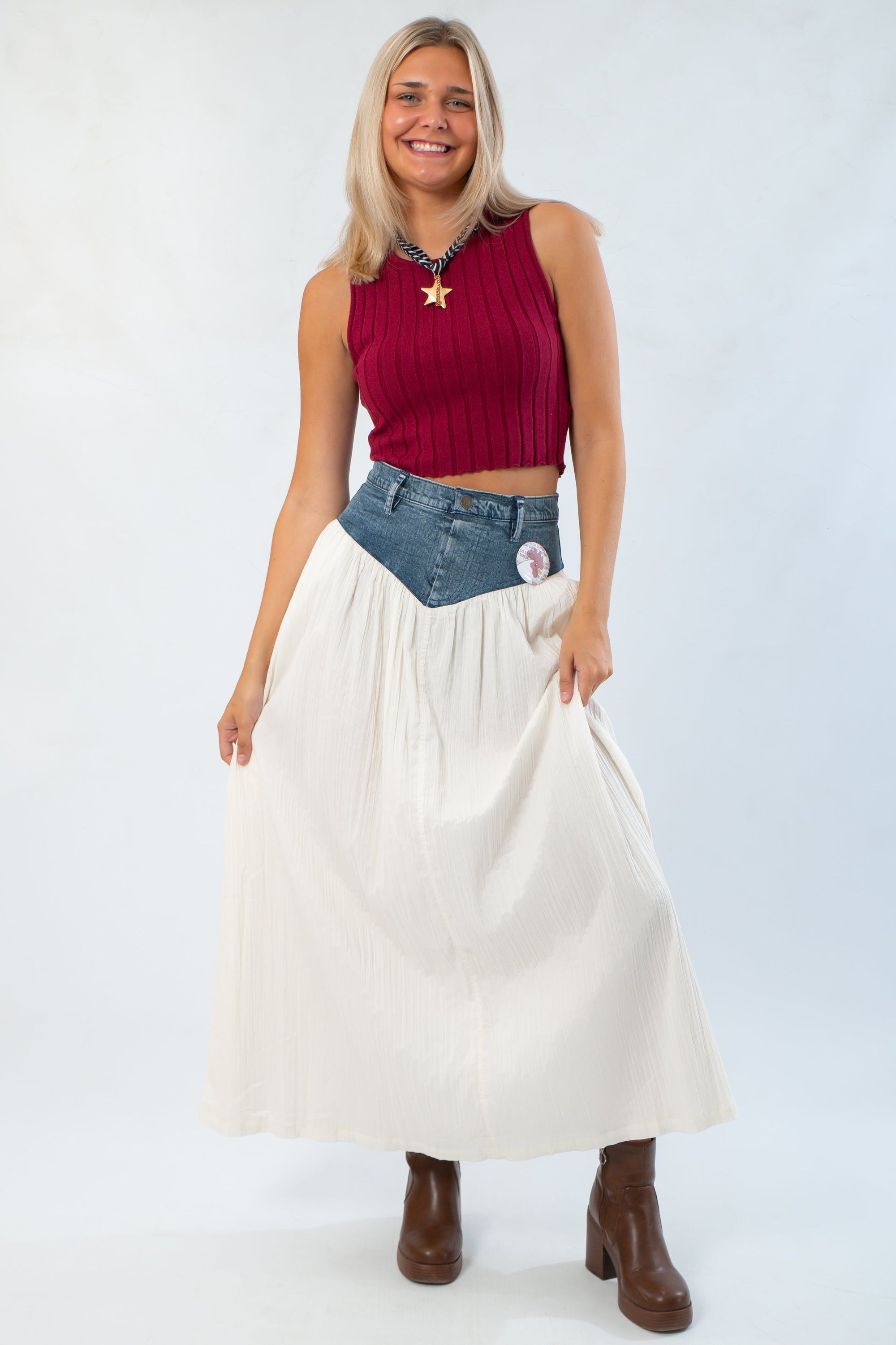 Show Me Your Mumu Denim Voile Maxi Skirt styled with a red ribbed crop top and brown boots, showcasing a chic fall outfit.