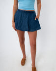 Close-up of denim skort with elastic waistband and ruffled top