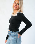 Side view of Free People Black Oh My Darling Long Sleeve – Slim Fit Lace Top showing fitted silhouette and scalloped sleeve detail.