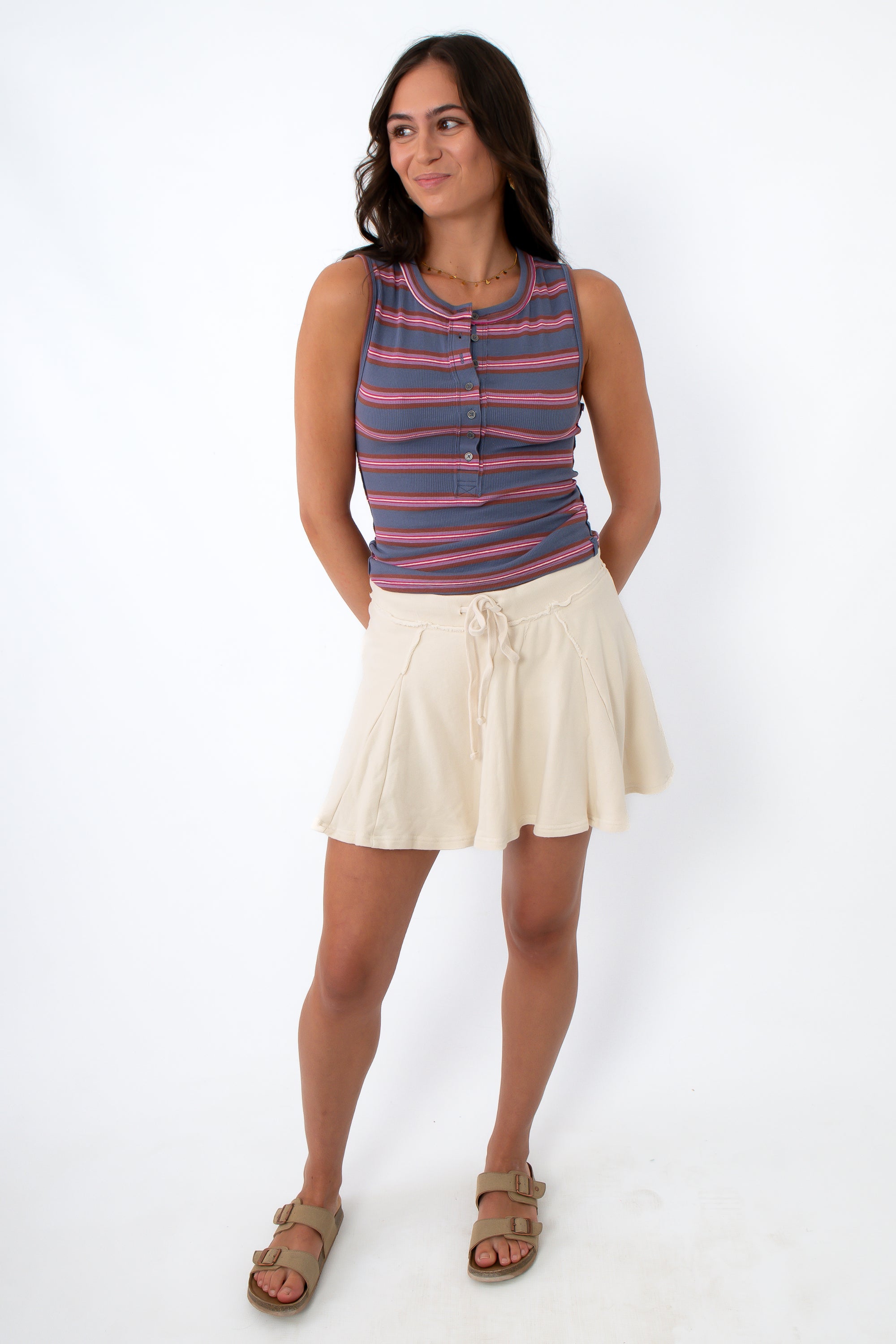woman wearing beige skort with striped tank top and sandals