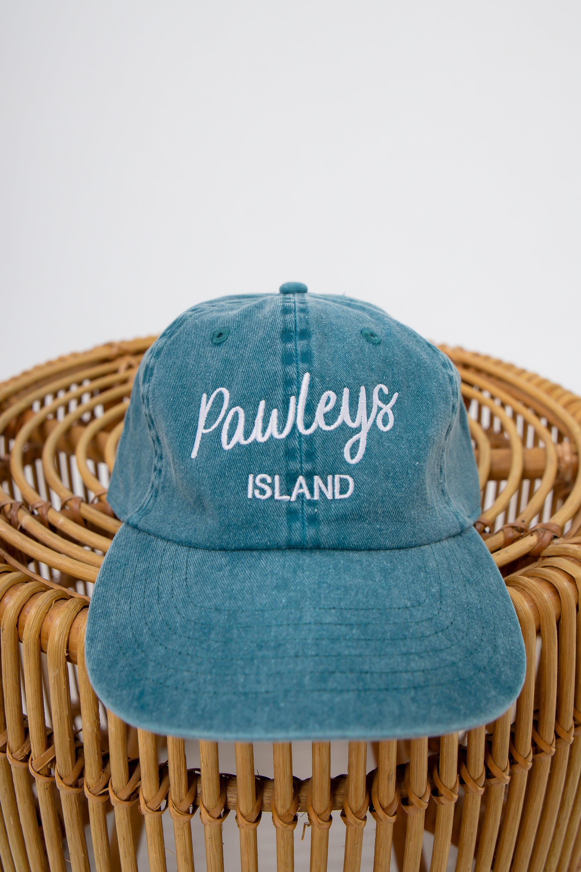 Sunwashed Pawleys Island embroidered baseball cap on wicker