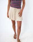 close-up of striped tank top and beige skort from front