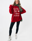 Festive red Show Me Your Mumu Twas The Night Knit Classic Crewneck Sweater paired with black leggings and silver boots for a cozy holiday look.