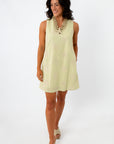 Woman in yellow embroidered sundress with shell necklace, front view