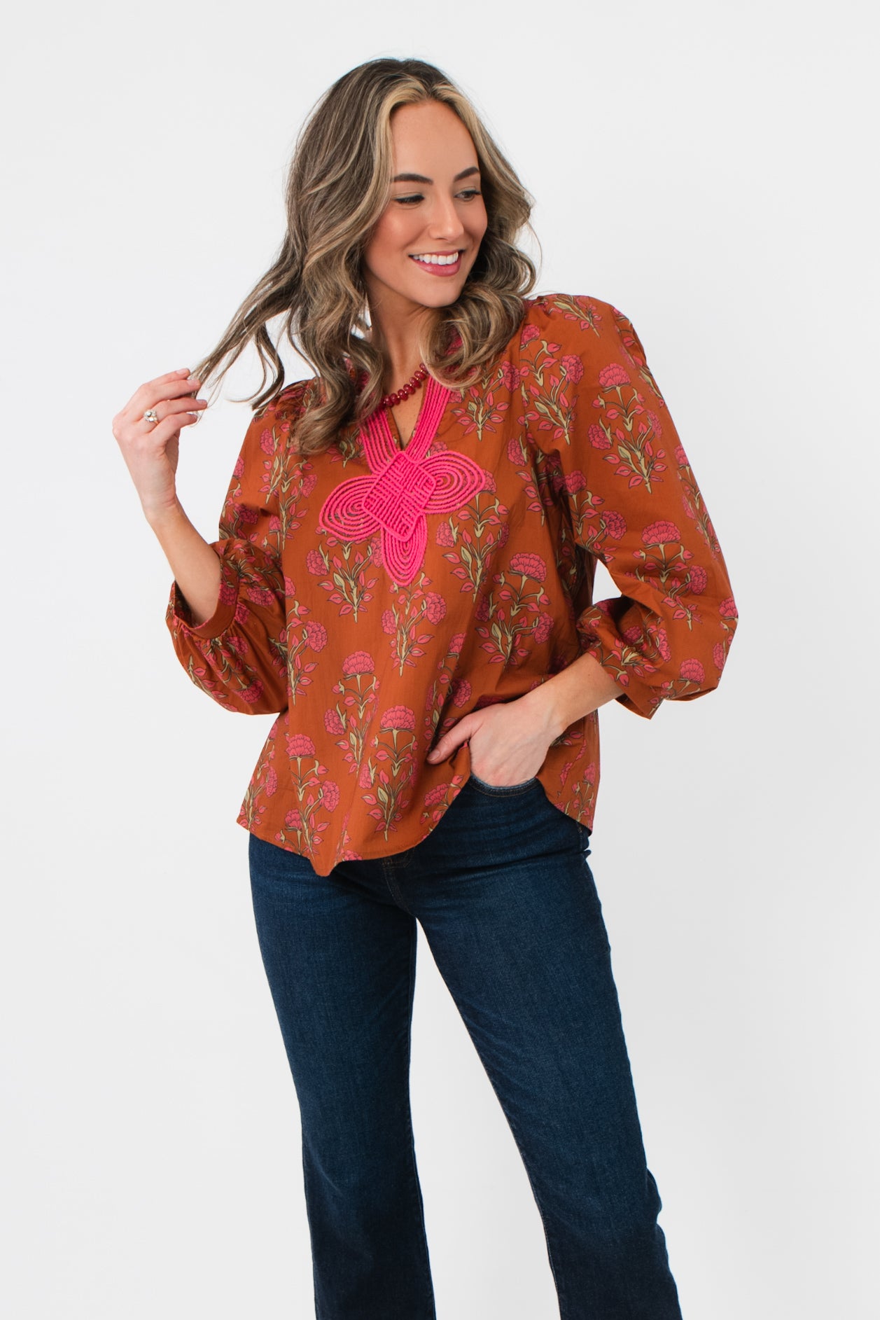 Carmen Rust Floral Embroidered Blouse with pink embroidery and balloon sleeves, styled with dark jeans for a chic fall outfit.