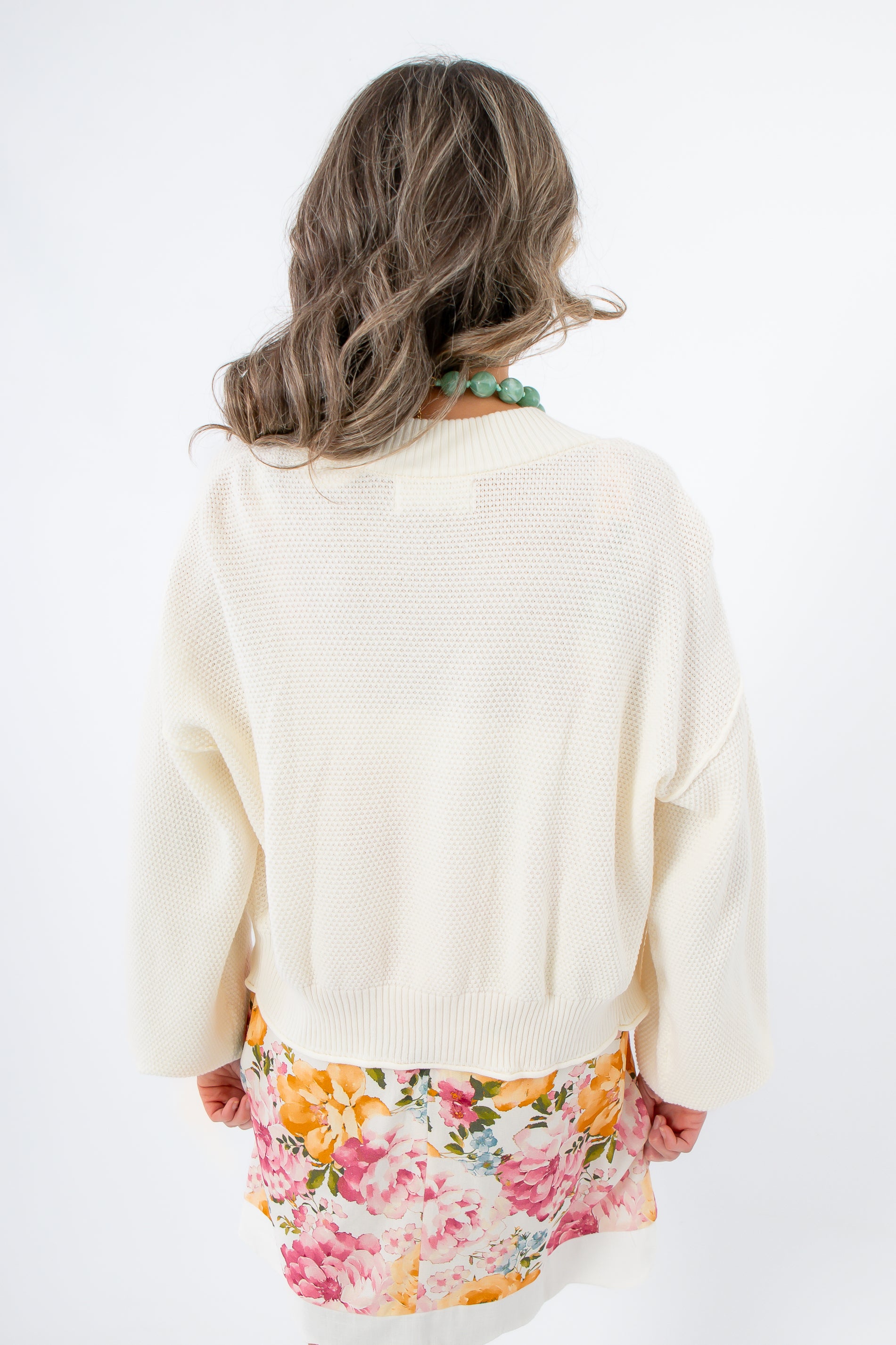 Back view of Clare Cream Waffle Knit Cardigan over floral dress