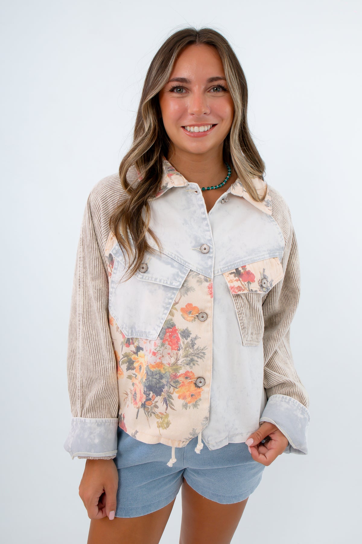 Lightwash jacket with corduroy striped patches and floral buttons. lightwash denim jacket, lightweight jacket with floral detail