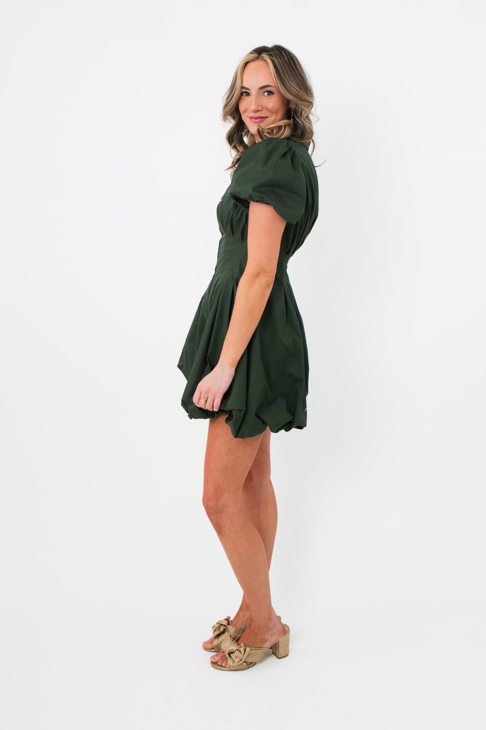 Profile angle of Arden Hunter Green Bubble Dress highlighting tailored fit, short length, and elegant puff sleeve detail.