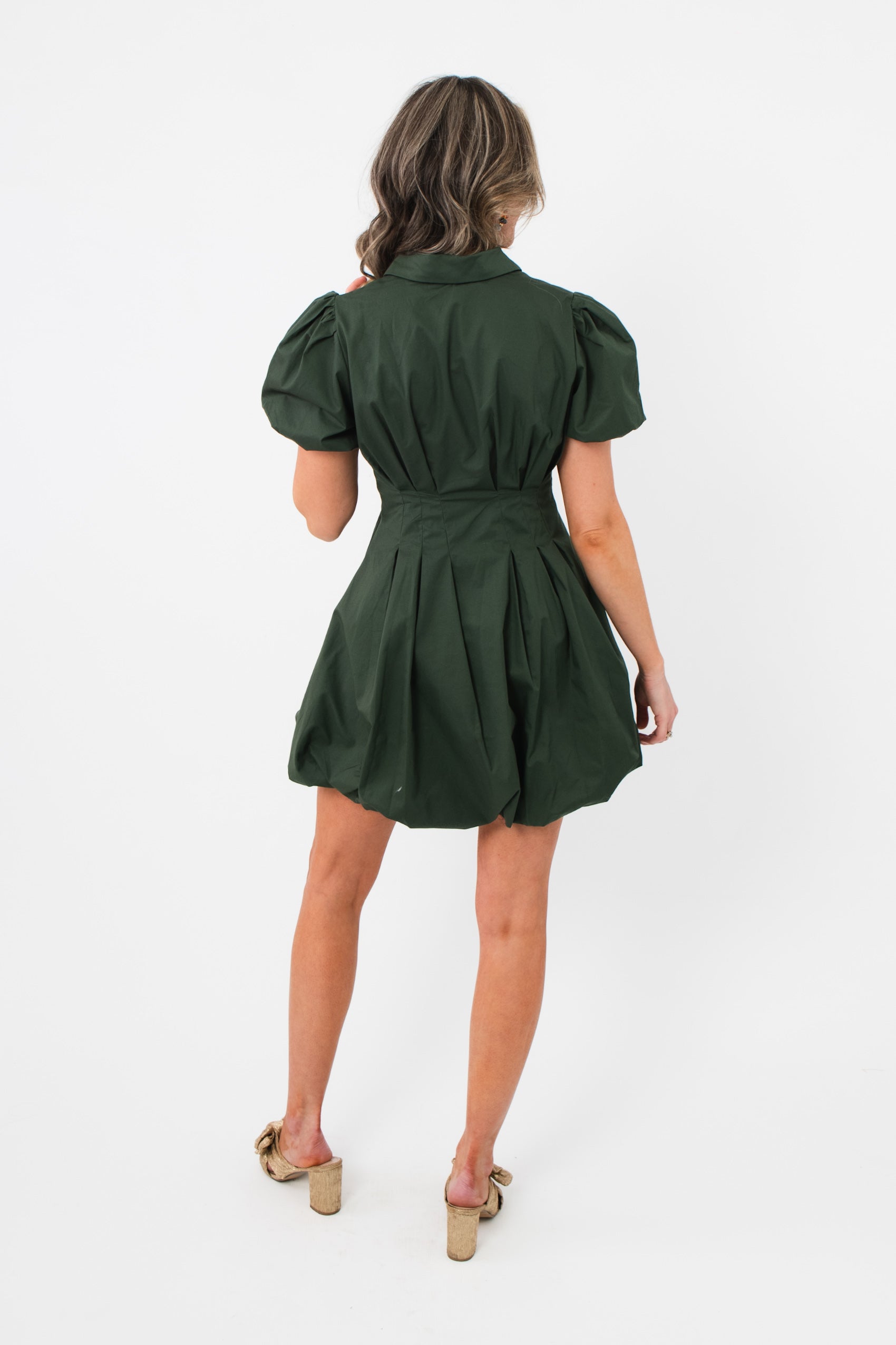 Back view of Arden Hunter Green Bubble Dress with pleated skirt, cinched waist, and short puff sleeves for a flattering silhouette.