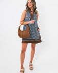 Maureen Chambray Medallion Shift Dress – Floral Sleeveless V Neck styled with a brown handbag and white sandals for a casual fall look.