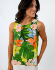 Close-up of woman with dark wavy hair, wearing tropical print sleeveless blouse, smiling, white background