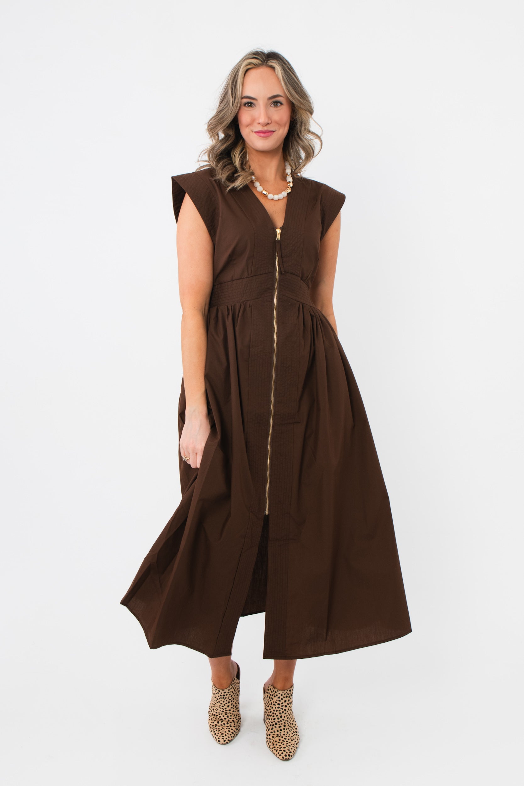 Brownstone Front Zip Sleeveless Midi Dress with V-neck and cinched waist, styled with leopard print heels for a chic fall look.