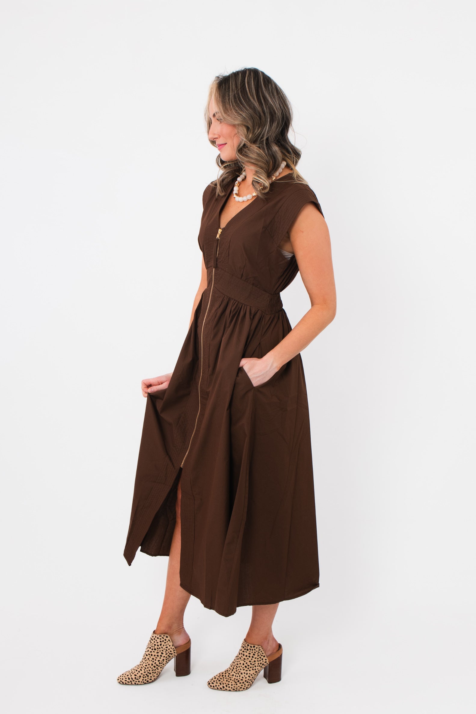 Side view of the Brownstone Front Zip Sleeveless Midi Dress showing its structured fit, midi length, and flowy skirt for effortless style.