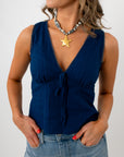 Profile of woman with wavy hair wearing navy blouse and star necklace