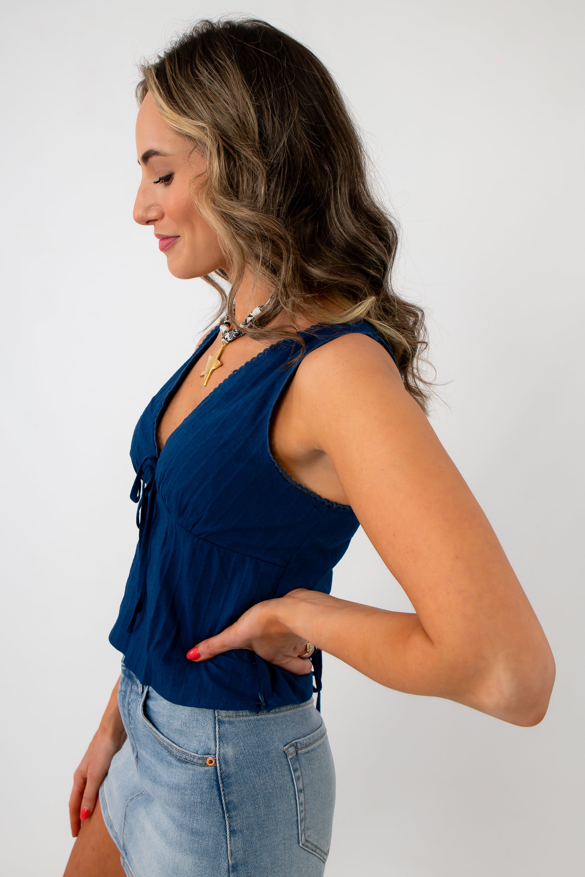 Back view of woman with navy eyelet trim blouse and tied ribbon detail