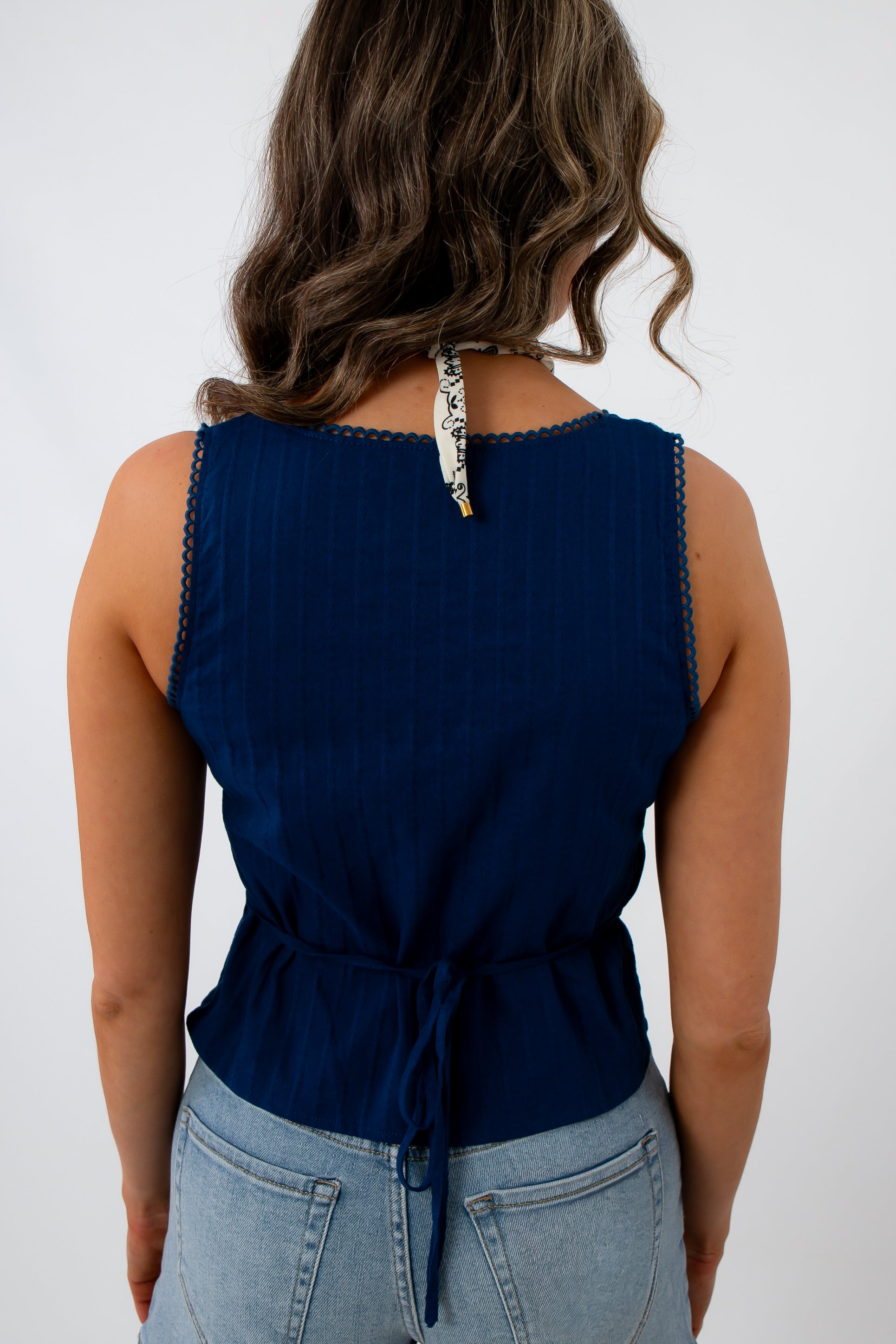 Navy eyelet trim blouse back view with ruffled hem