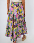 Woman in white top and floral maxi skirt with beige platform sandals