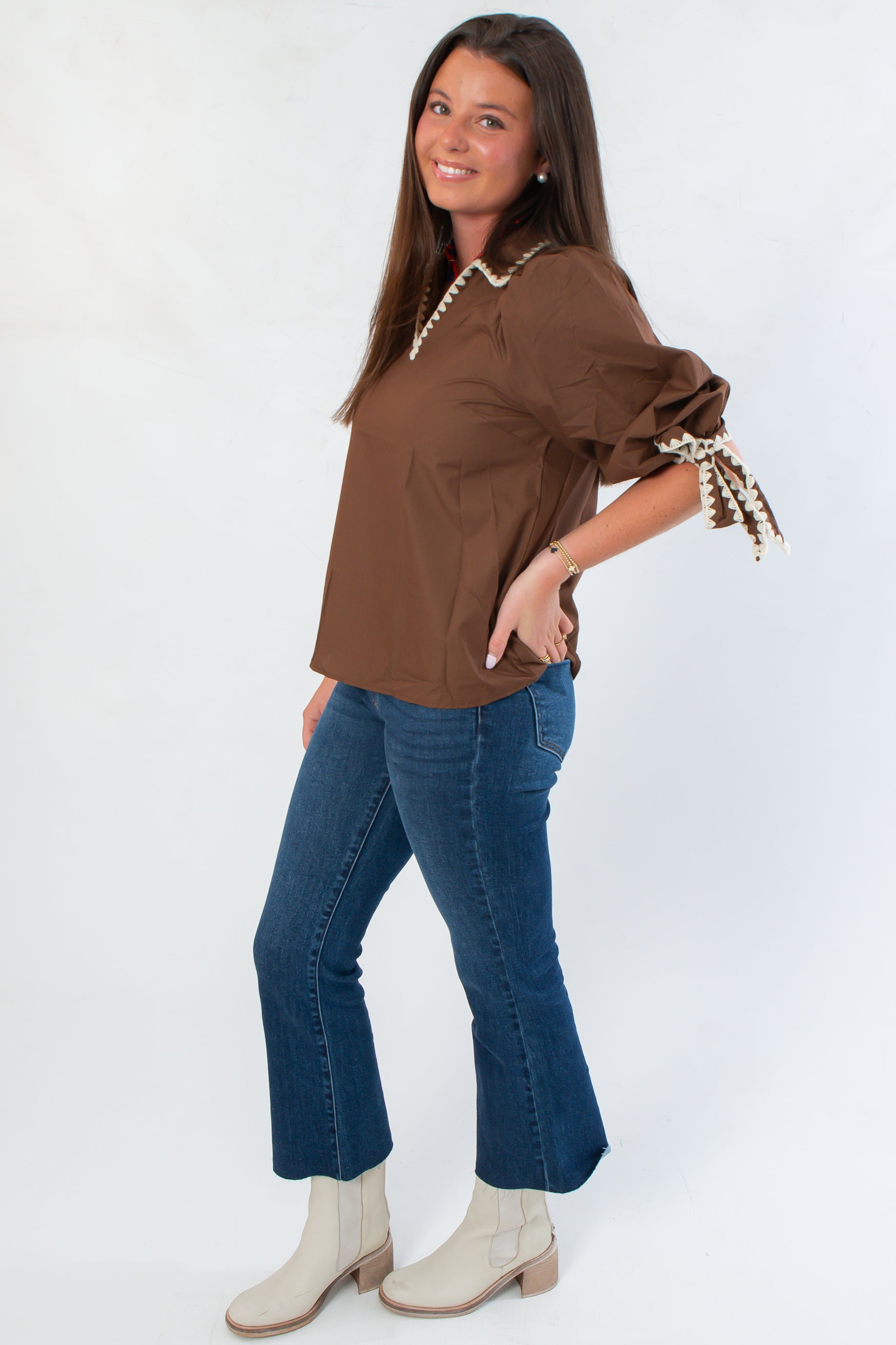 Side view of Hazel Brown Whipstitch Collared Blouse showing puff sleeves and detailed whipstitch trim, styled with denim and boots.