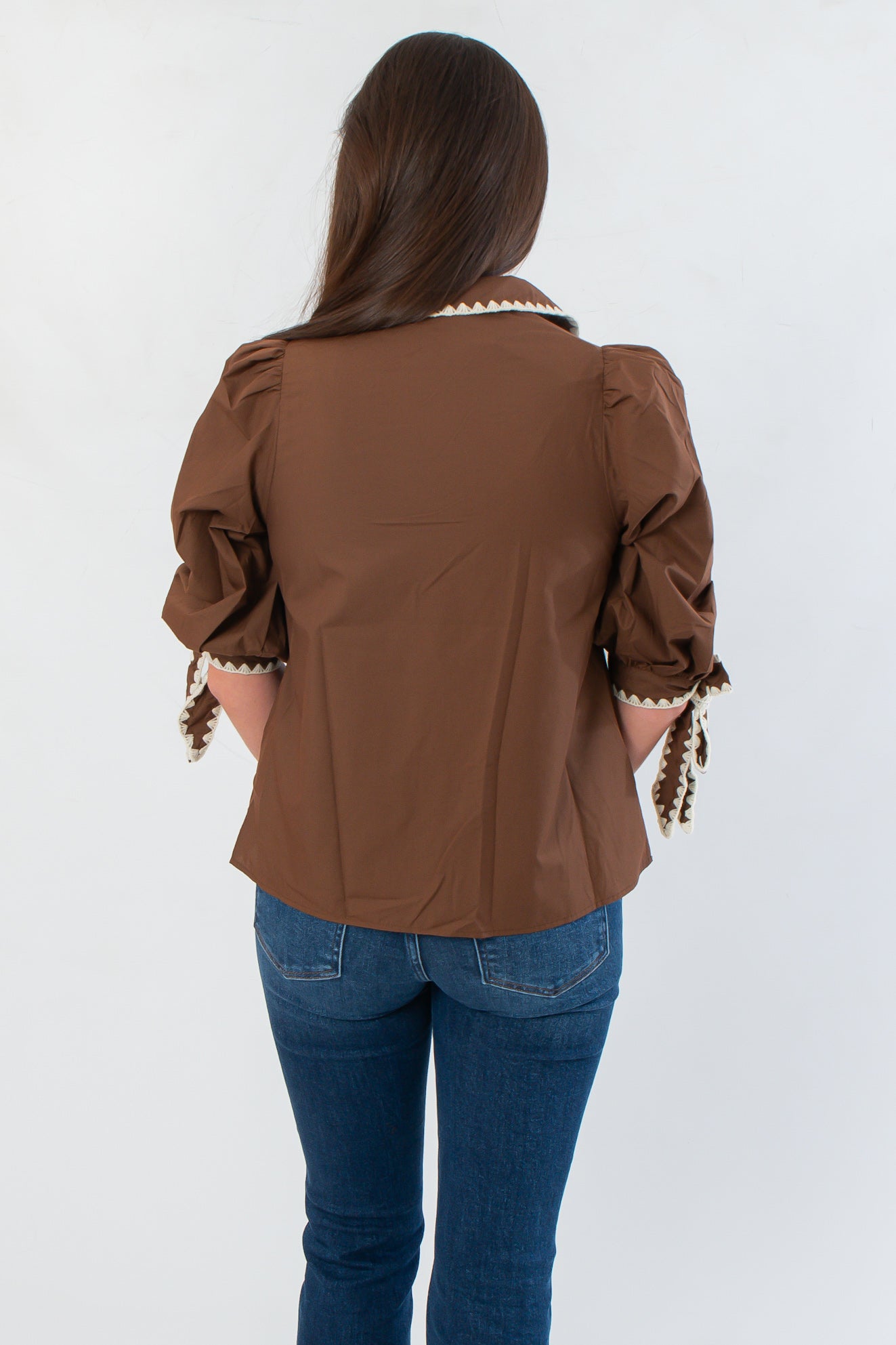 Back view of Hazel Brown Whipstitch Collared Blouse highlighting clean lines and neutral tone, a versatile top for seasonal styling.