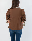 Back view of Hazel Brown Whipstitch Collared Blouse highlighting clean lines and neutral tone, a versatile top for seasonal styling.