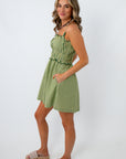 Back view of woman in green striped dress with ruffled top, showing dress straps and back details