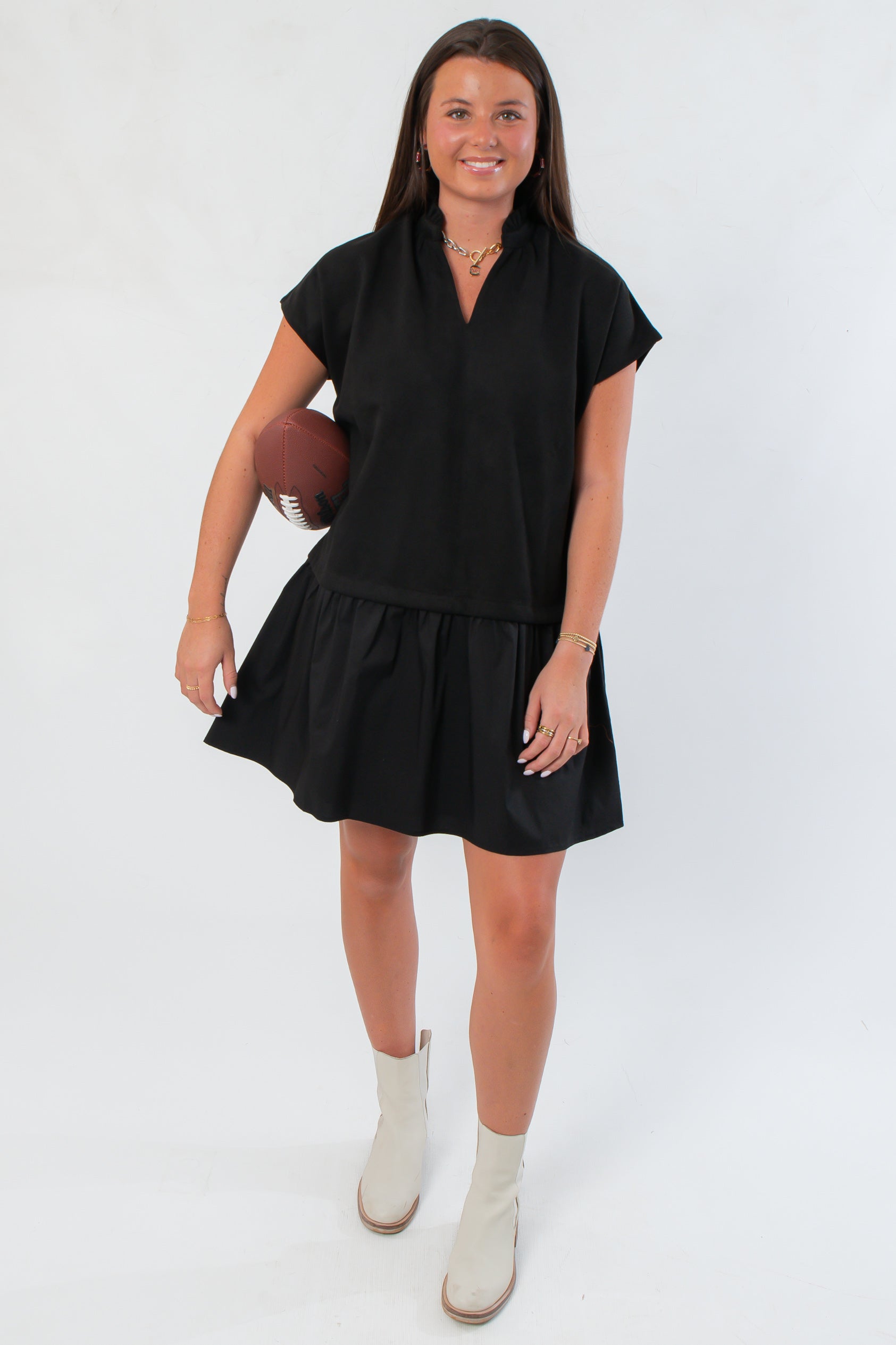 THML Elise Black Suede Mini Dress with V neckline and short sleeves, styled with white ankle boots for a chic, casual look.
