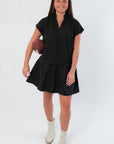 THML Elise Black Suede Mini Dress with V neckline and short sleeves, styled with white ankle boots for a chic, casual look.