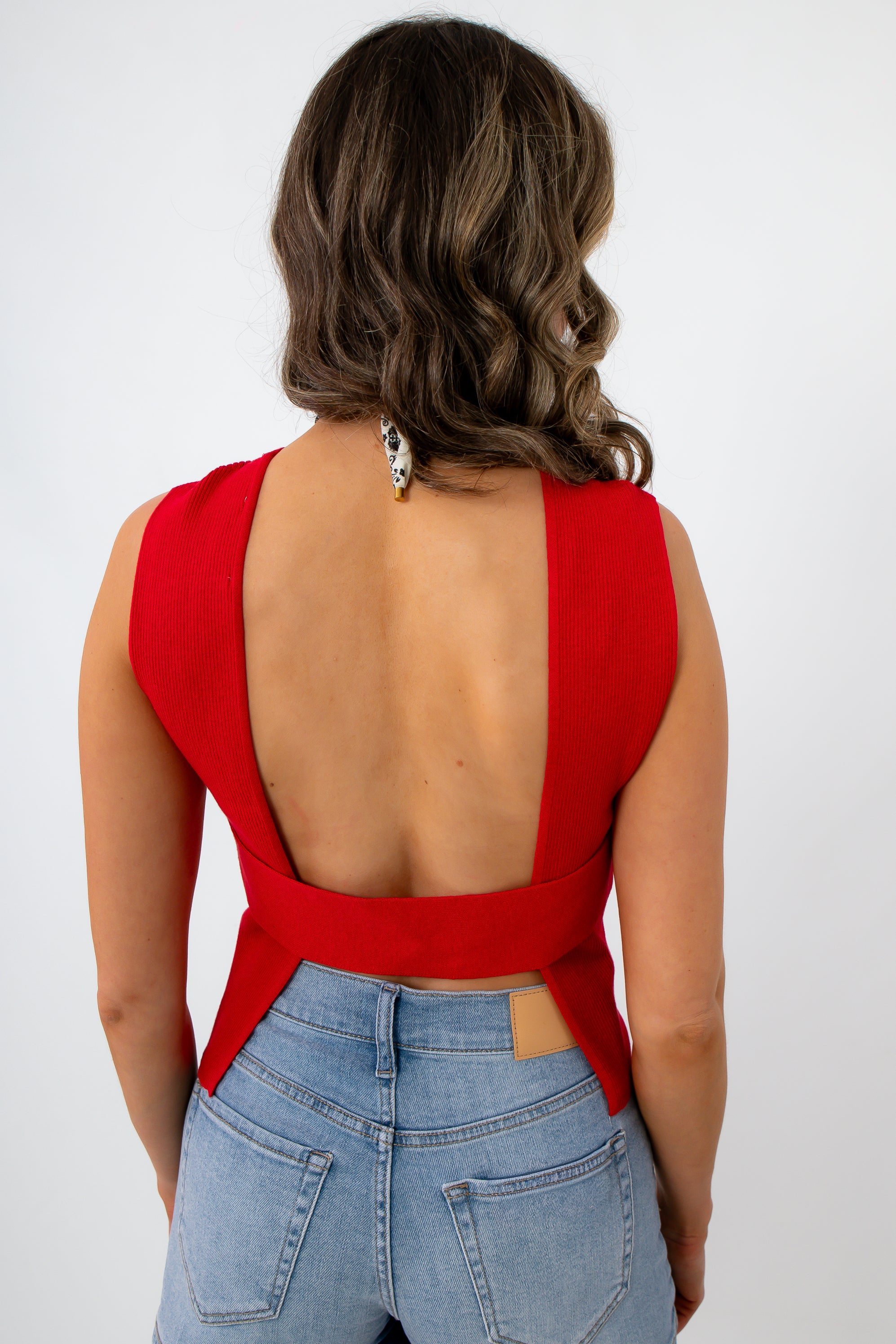 Woman in red sleeveless knit top with open back at go-kart track