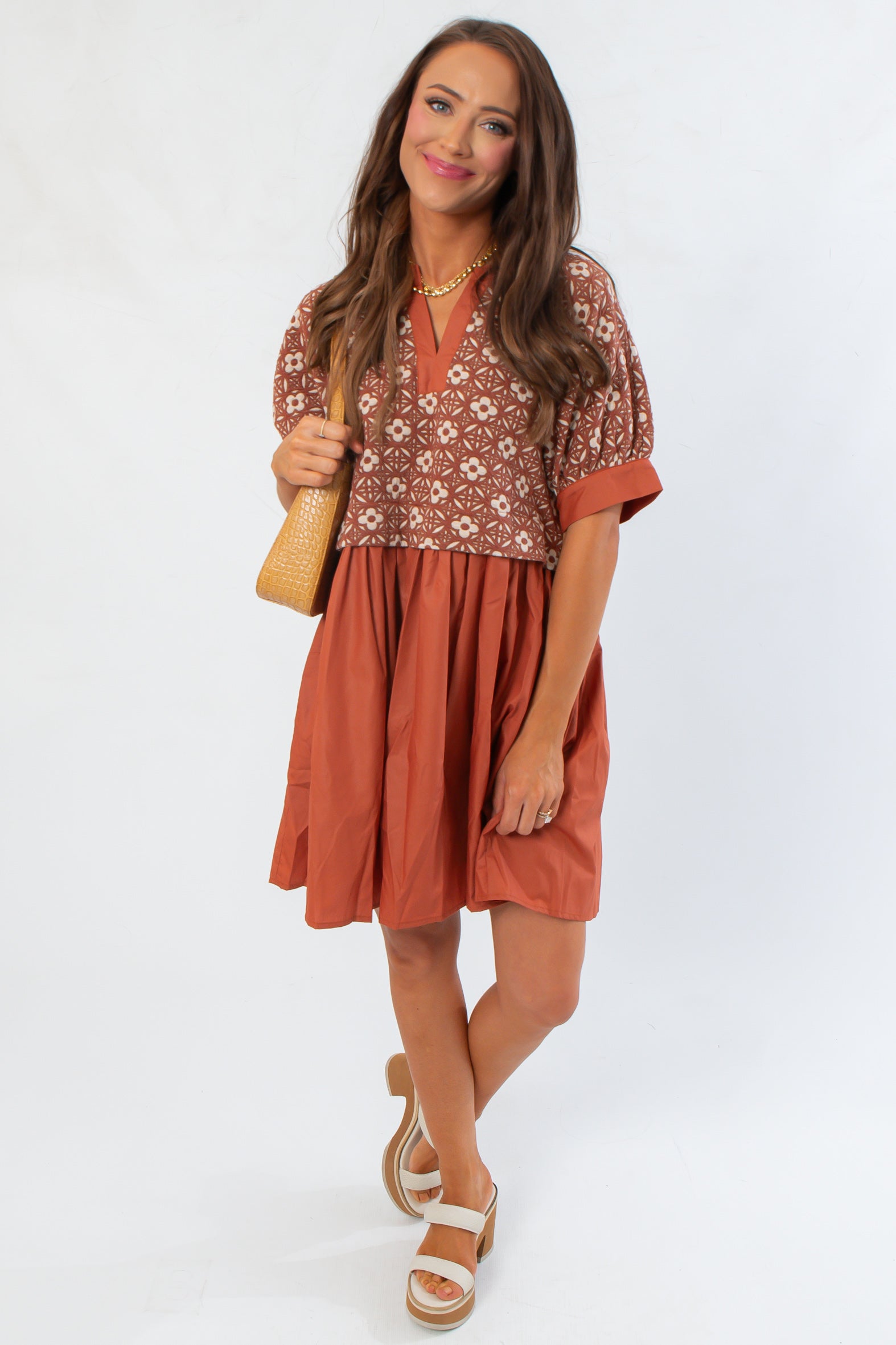 Rust embroidered babydoll dress featuring a flowy skirt and V-neckline, ideal for fall fashion or Thanksgiving events.