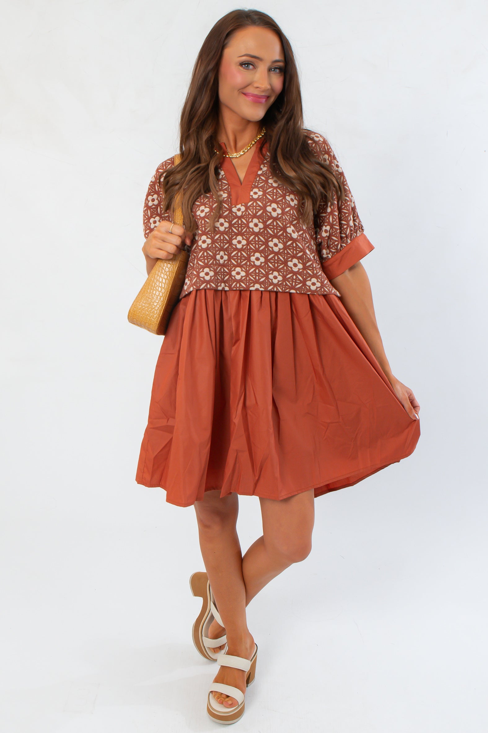 Chateau Chic Rust Embroidered Babydoll Dress with flared silhouette and textured top, perfect for casual autumn outings.
